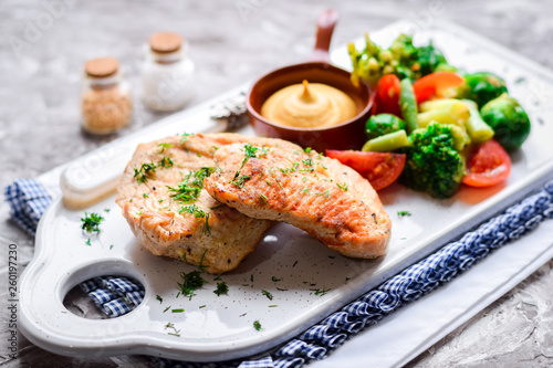 Fried chicken breast with mustard sauce and fresh vegetables.