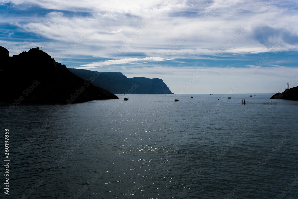 Picturesque sky, dark silhouettes of mountains and the sea Picturesque sky, dark silhouettes of mountains and the sea