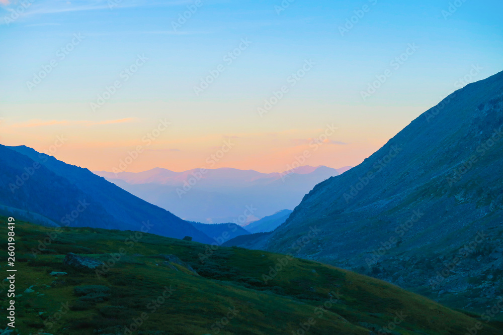 Sunset above the mountains ridge in Akchan valley. Altai Mountains. Russia