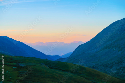 Sunset above the mountains ridge in Akchan valley. Altai Mountains. Russia