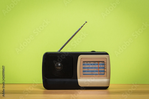 old radio on wooden table with color wall background
