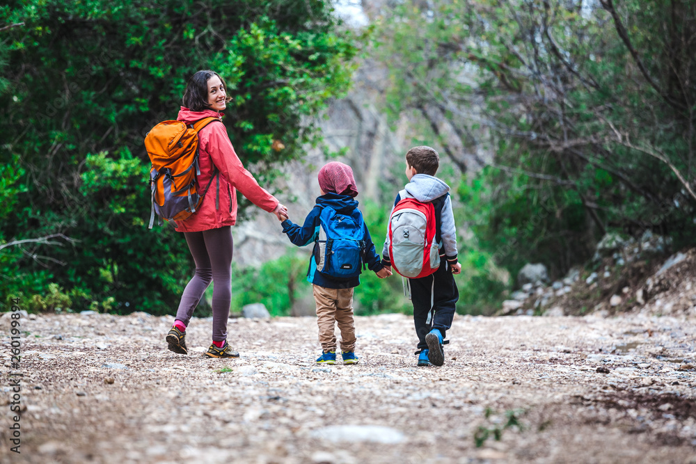 A woman with two children goes through the forest. A woman with two children goes through the forest.