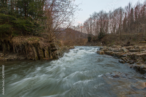 Rapid mountain river with a strong current in the early spring. Rapid Carpathian River with a strong current in the early spring.