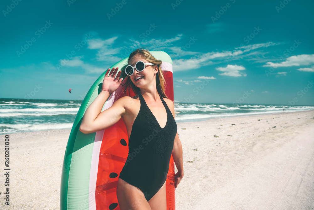 Model with watermelon lilo at the beach