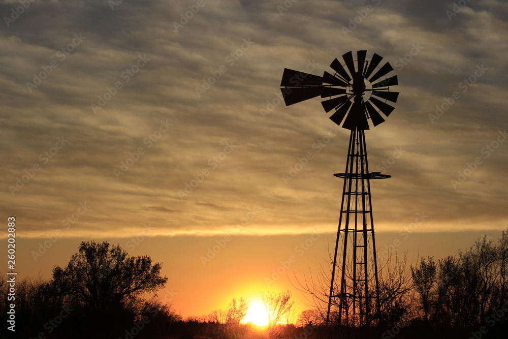 Kansas Windmill Silhouette at Sunset with clouds Kansas Windmill Silhouette at Sunset with clouds