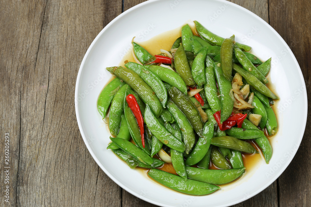 Green string bean fried oyster sauce of Thai foods on wooden floor. Green string bean fried oyster sauce of Thai foods on wooden floor.