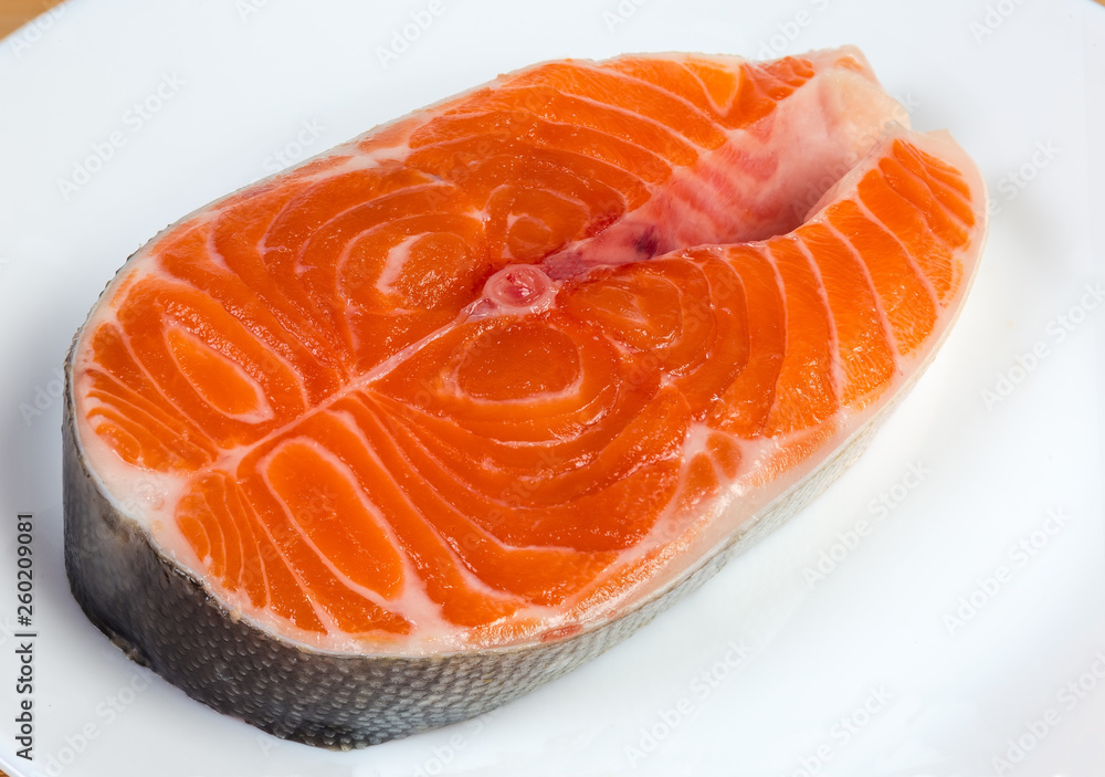 Uncooked steak of arctic char on dish close-up Uncooked steak of arctic char on dish close-up