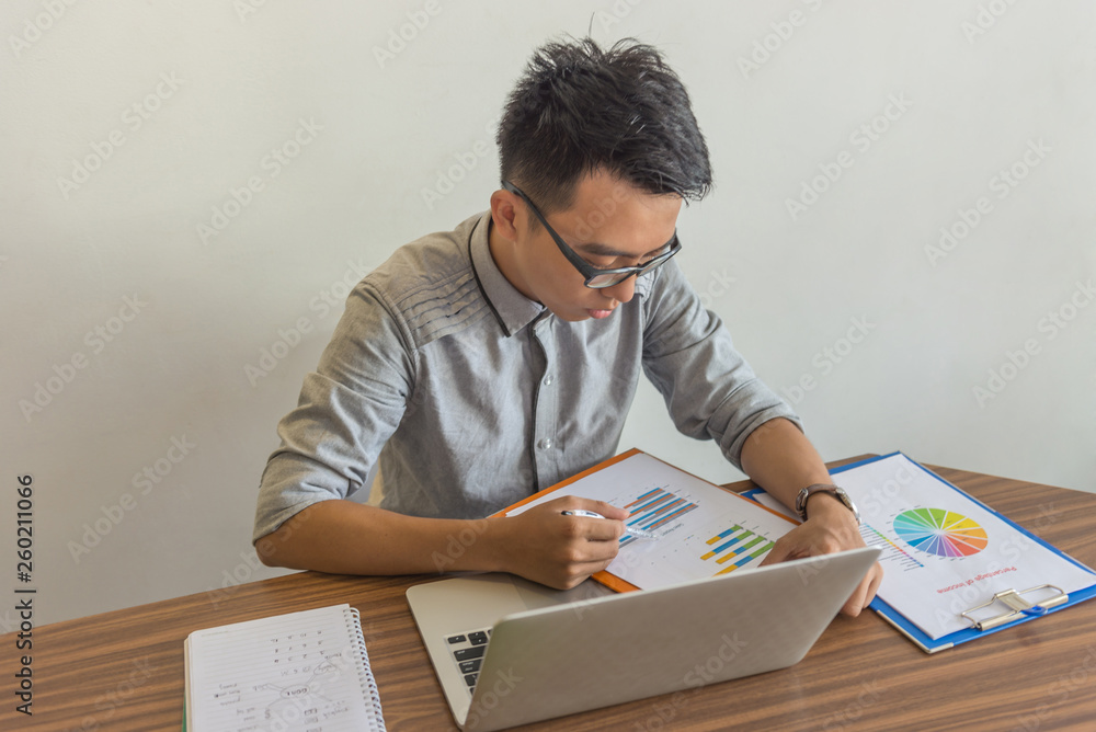 Young office man reading financial report document Young office man reading financial report document