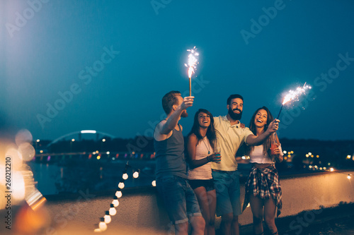 Group of happy friends celebrating at rooftop photo