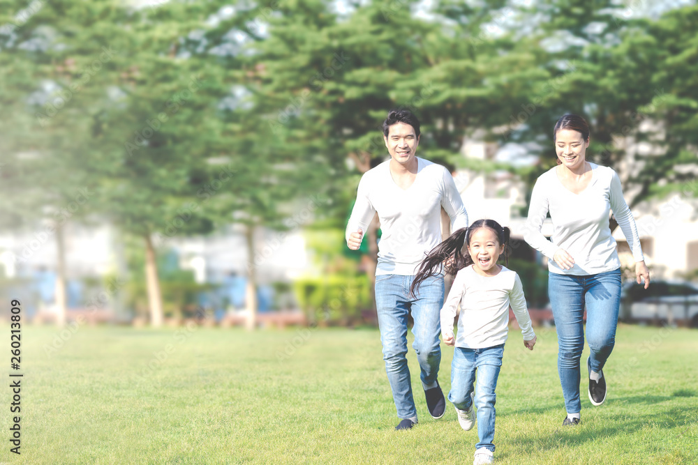 Young attractive happy asian family playing by running together in outside nature park in home school learning or montessori concept with white and blue casual wearing. Asian lifestyle parenting. Young attractive happy asian family playing by running together in outside nature park in home school learning or montessori concept with white and blue casual wearing. Asian lifestyle parenting.