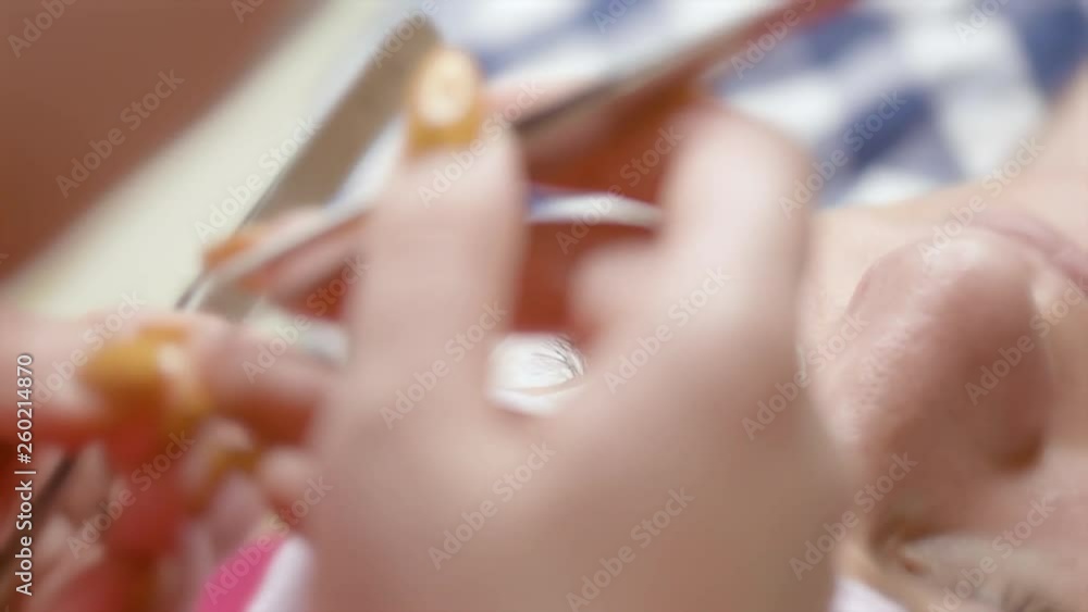 Eyelash Extension in modern Beauty salon. Woman Eye with long Eyelashes. Professional Beautician with tweezers is making eyelash extension to client at Cosmetic Procedure. Eyelash Extension in modern Beauty salon. Woman Eye with long Eyelashes. Professional Beautician with tweezers is making eyelash extension to client at Cosmetic Procedure.