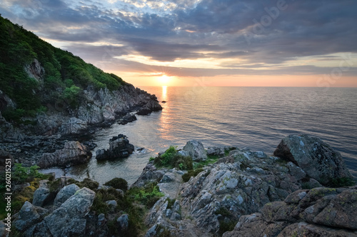 Amazing sunset in the sea with the rocky and harsh coast cliff of Kullaberg nature reserve