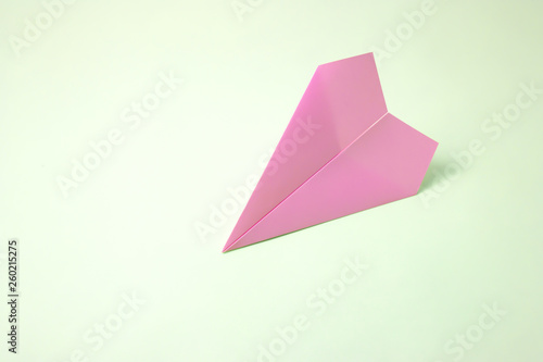 paper airplane on pastel background. Minimal flat lay school concept.