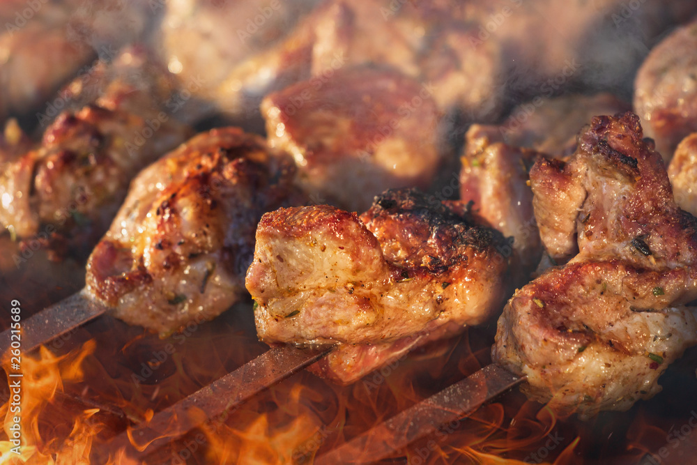 Marinated shashlik preparing on a barbecue grill over charcoal. Shashlik or Shish kebab popular in Eastern Europe. Shashlyk, skewered meat. was originally made of lamb.