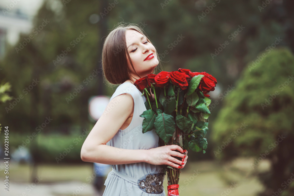 Φωτογραφία beautiful young woman with a large bouquet of flowers in the park
