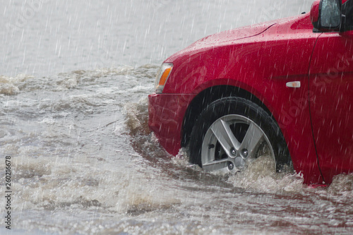Street in the heavy rain - flood road . red car moving