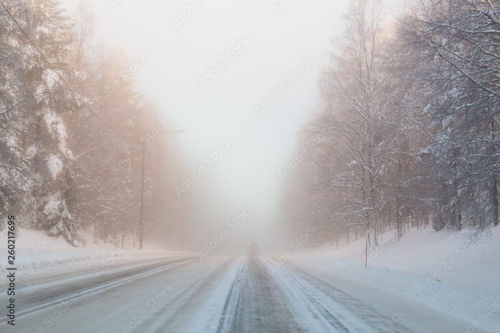 Obraz premium Winter snow-covered road in Finland. Heavy fog.