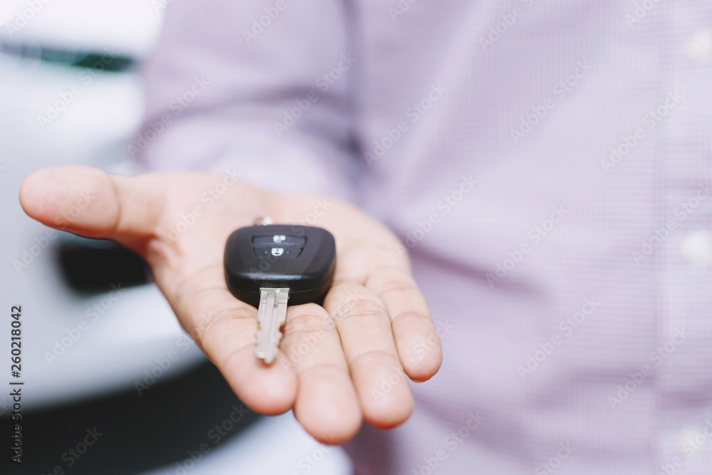 Car key, businessman handing over gives the car key to the other man on car background. Car key, businessman handing over gives the car key to the other man on car background.