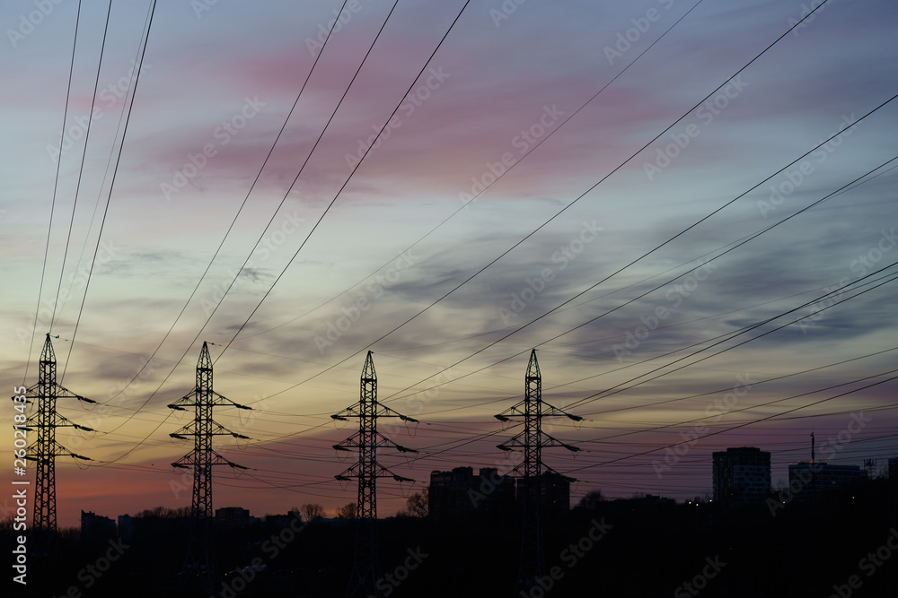 Voltage towers with sky background at the sunset. Image of overhead power lines.