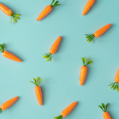 Easter pattern made with carrots on bright blue background. Creative minimal holiday concept. Flat lay.