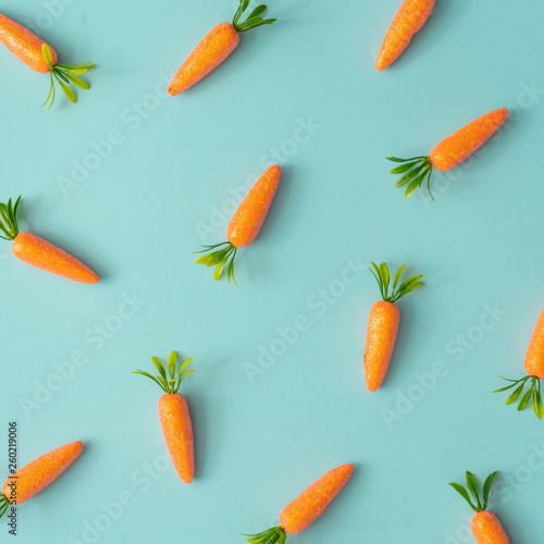 Easter pattern made with carrots on bright blue background. Creative minimal holiday concept. Flat lay.