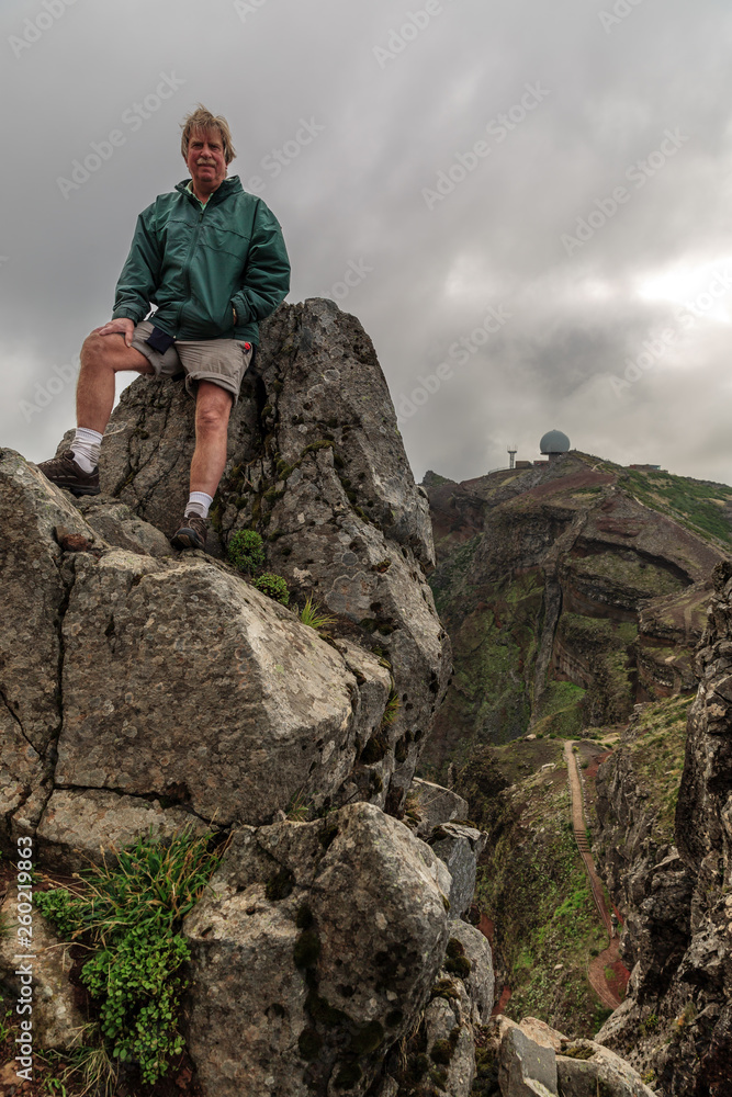 Senior tourist in the mountains of Madeira at Pico do Areeiro (Arieiro), while hiking to Pico Ruivo on a cloudy summer day