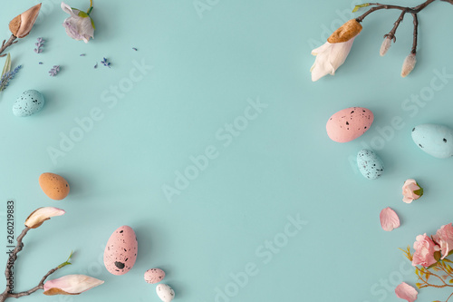 Photography Easter composition made with flowers and eggs on bright blue background with ribbon copy space