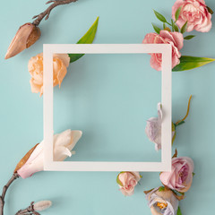 Easter composition made with flowers and eggs on bright blue background with ribbon copy space. Creative minimal holiday concept. Flat lay.