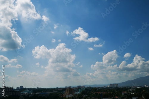 white cloud on clear blue sky above the town © sutichak
