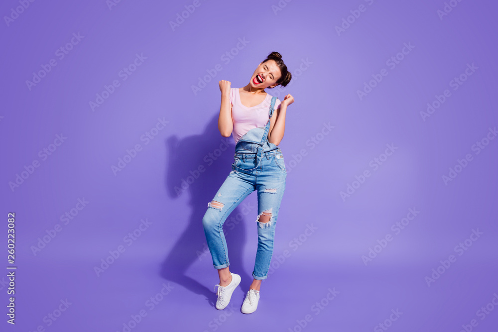 Full length body size photo yelling roar beautiful funky she her lady two buns hands arms up cheerleader wear casual t-shirt jeans denim overalls outfit isolated purple violet bright background Full length body size photo yelling roar beautiful funky she her lady two buns hands arms up cheerleader wear casual t-shirt jeans denim overalls outfit isolated purple violet bright background