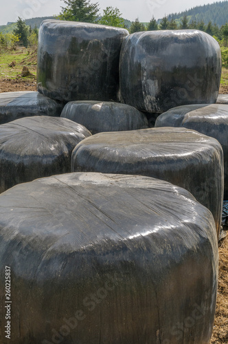 Close up of bales of hay wrapped in black plastic