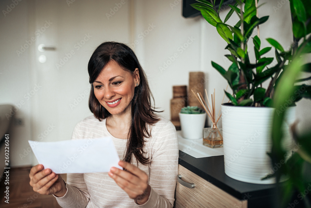 Φωτογραφία Beautiful casual happy woman looking at received letter.
