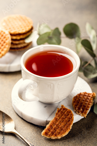 Cup of tea with syrupwaffles cookies