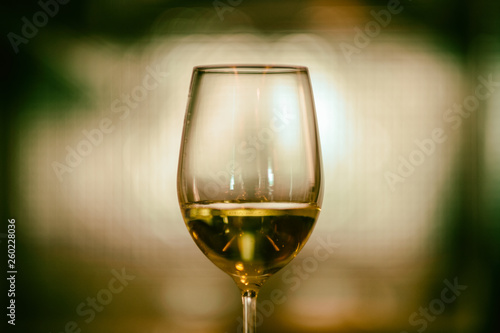 Closeup image of champagne in a wine glass with blurred light background