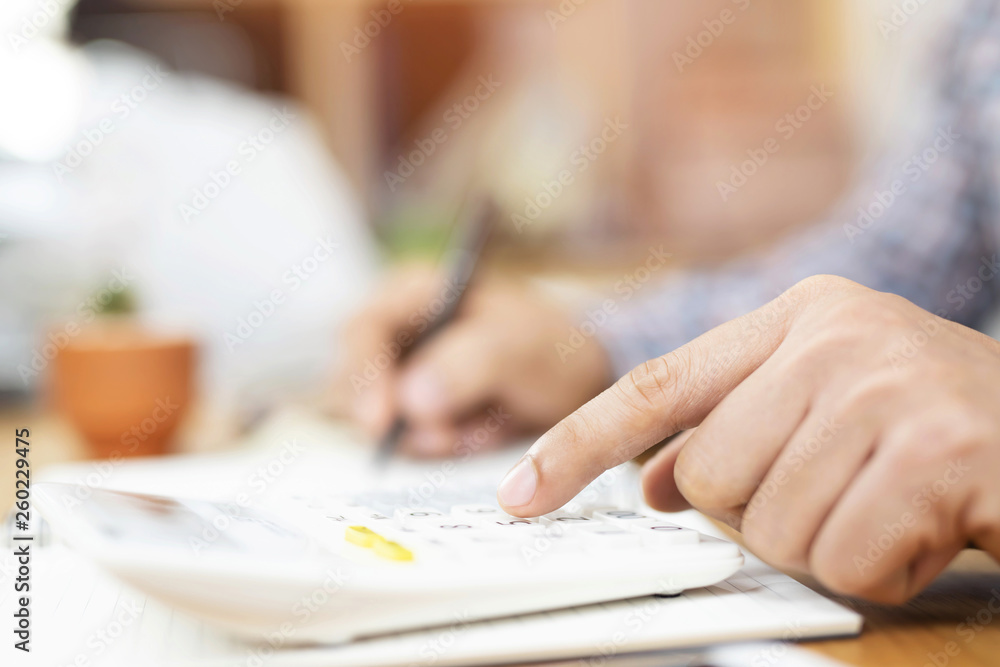 Close up business man hand is writing in a notebook and using calculator counting making notes Accounting at doing finance on desk at office. Savings finances concept. note pad Close up business man hand is writing in a notebook and using calculator counting making notes Accounting at doing finance on desk at office. Savings finances concept. note pad