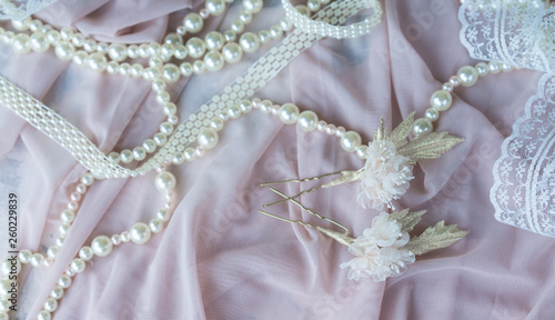 Wedding background with pearls and hair accessories on pink background