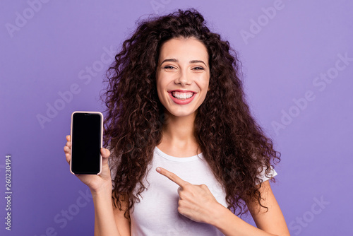 Close-up portrait of nice cute attractive winsome lovely cheerful wavy-haired lady showing new product ad promotion isolated on bright vivid shine violet pastel background