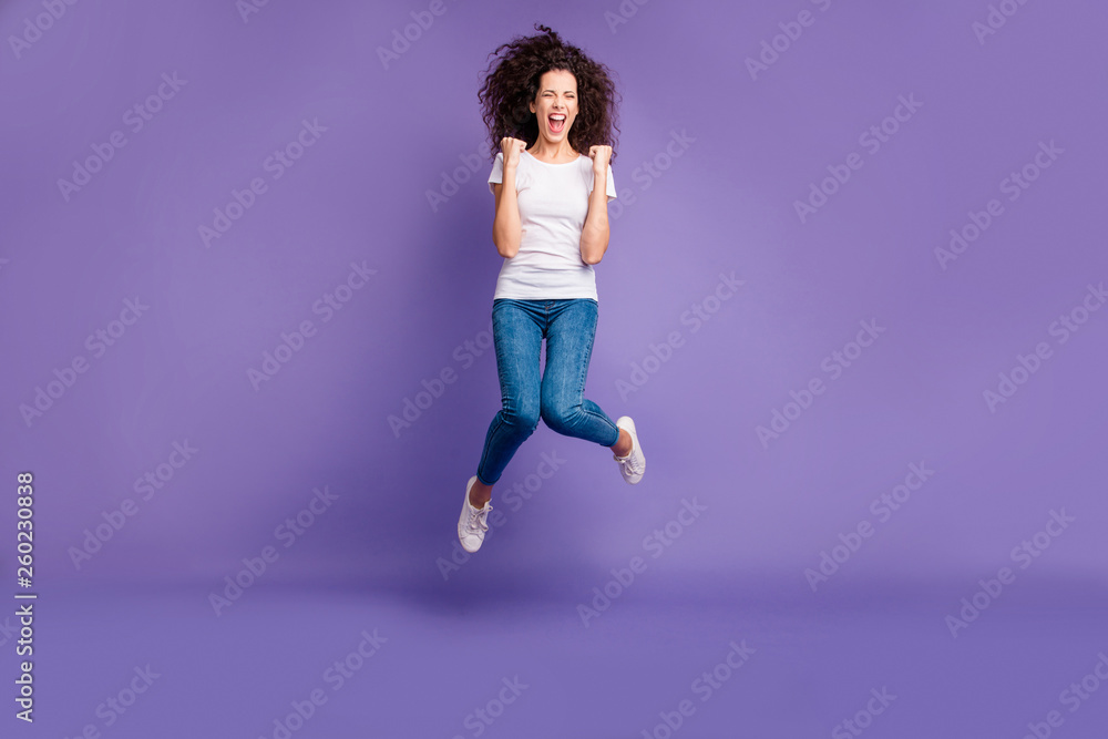 Full length body size photo yelling beautiful she her lady fists cheerleader jump high discount sale shopping wear casual jeans denim white t-shirt sneakers isolated purple violet bright background Full length body size photo yelling beautiful she her lady fists cheerleader jump high discount sale shopping wear casual jeans denim white t-shirt sneakers isolated purple violet bright background