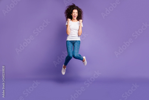 Full length body size photo yelling beautiful she her lady fists cheerleader jump high discount sale shopping wear casual jeans denim white t-shirt sneakers isolated purple violet bright background