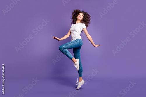 Full length side profile body size photo beautiful amazing she her lady jump high spread hands arms cheerleader wear casual jeans denim white t-shirt sneakers isolated purple violet bright background