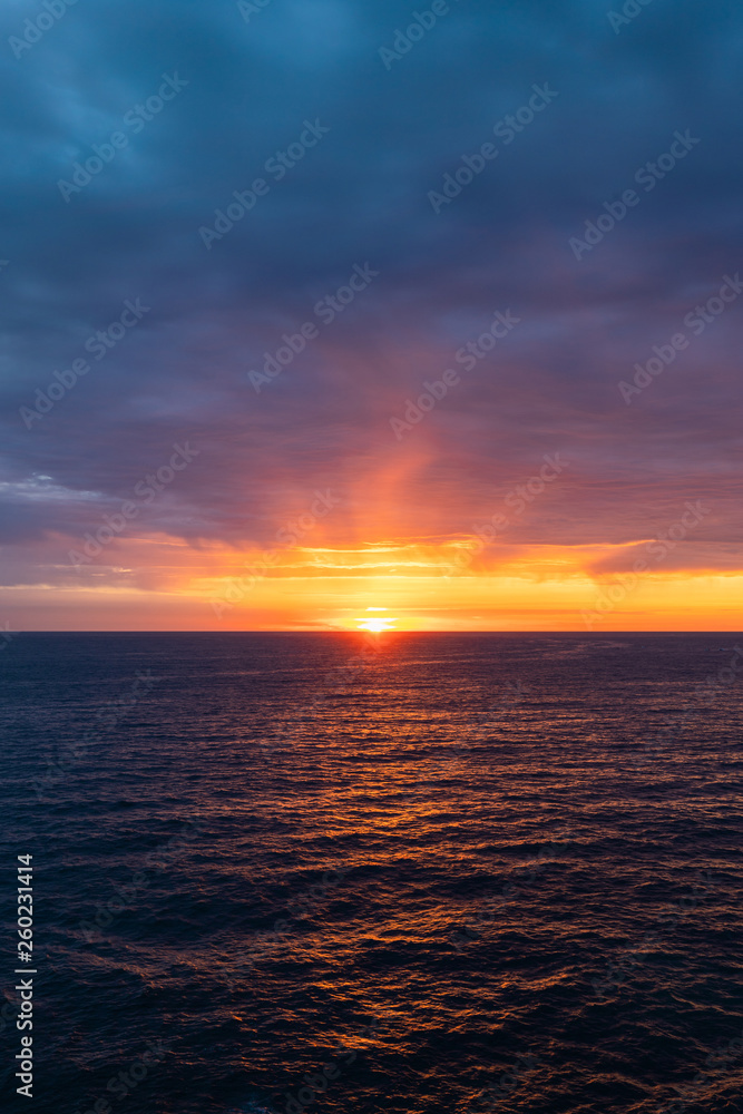 Cloudy sunrise view over the ocean horizon.