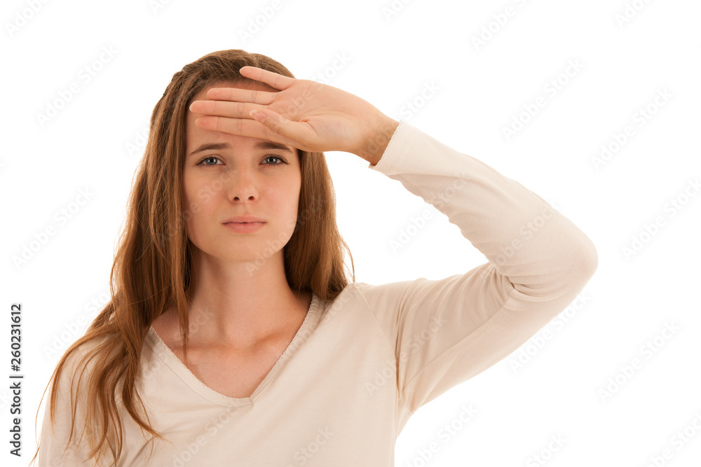 Beautiful young brunette woman holds her head as she has headache - illness