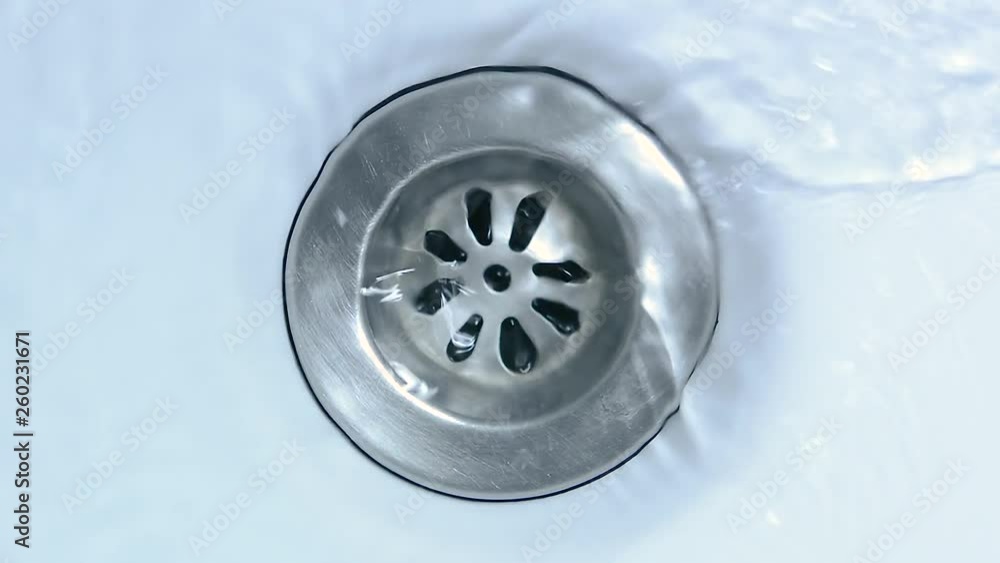 Water running down the drain. Streaming water in sink. Water running down the drain. Streaming water in sink.