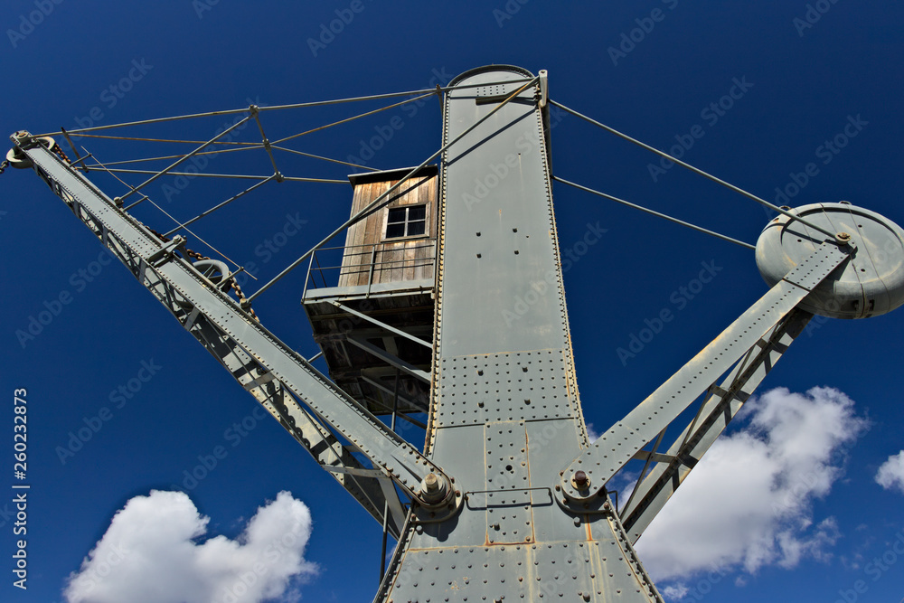 Obraz premium Genoa. Ancient crane at the port. Some ancient cranes used for loading / unloading ships have been left as symbols of industrial archeology.