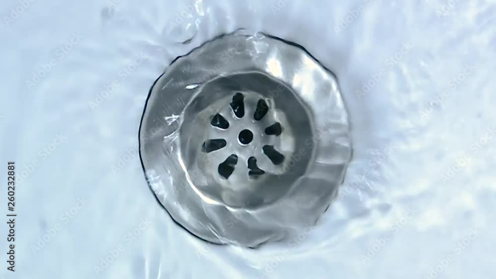 Water running down the drain. Streaming water in sink. Water running down the drain. Streaming water in sink.