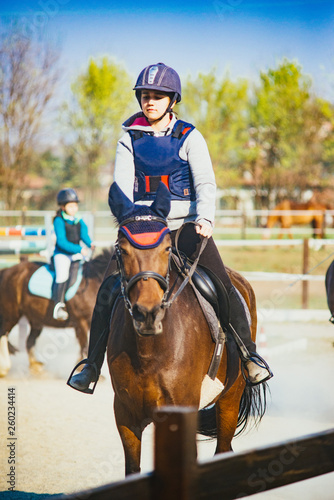 Girl rides her horse in the outdoor riding-little girl takes outdoor riding lesson © Emanuele Capoferri