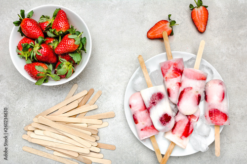 Natural juicy strawberry popsicles with yogurt. Refreshing ice pops, overhead, flat lay