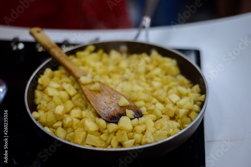 finely chopped apples are fried in sugar on a black frying pan