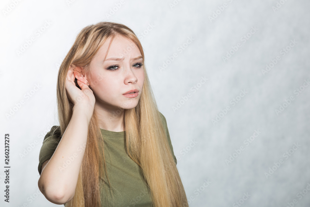 Young woman trying to hear better by attaching his palm to ear. Young woman trying to hear better by attaching his palm to ear.