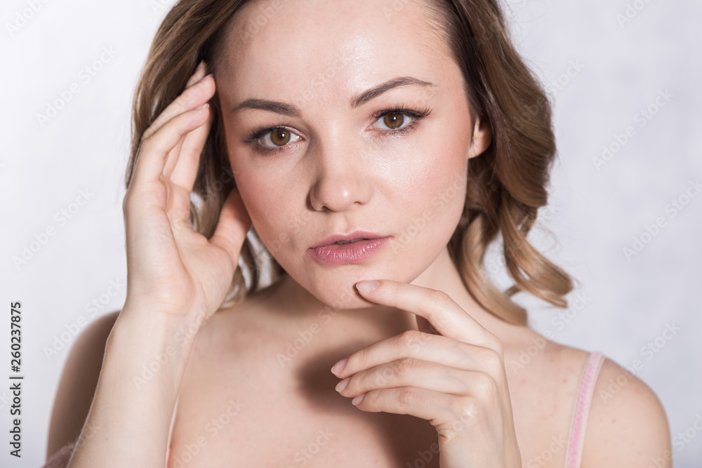 Portrait of beautiful young elegant female in pale pink wedding dress with big neckline, on a white background.